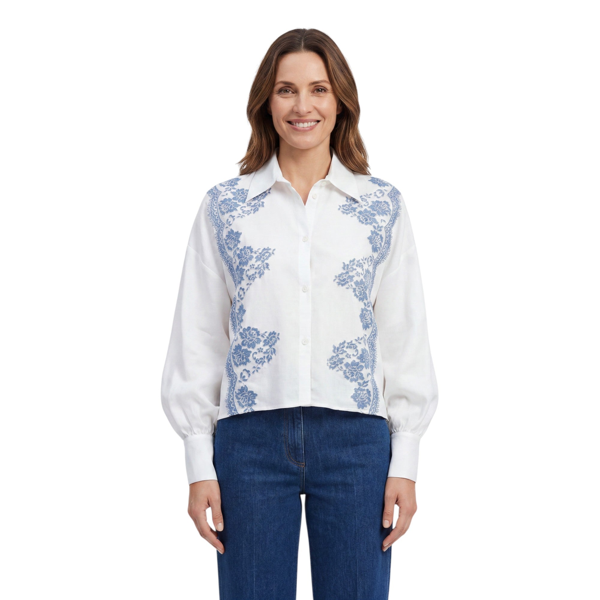 Front view of a smiling model wearing the Ermanno Firenze white blouse with blue lace details, styled with dark blue jeans from BLUE SALON shop.