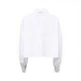 Back view of the Ermanno Firenze cropped white blouse showcasing the clean back panel and draped voluminous sleeves, available at BLUE SALON shop.