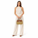Woman holding a brown handbag against a white background.