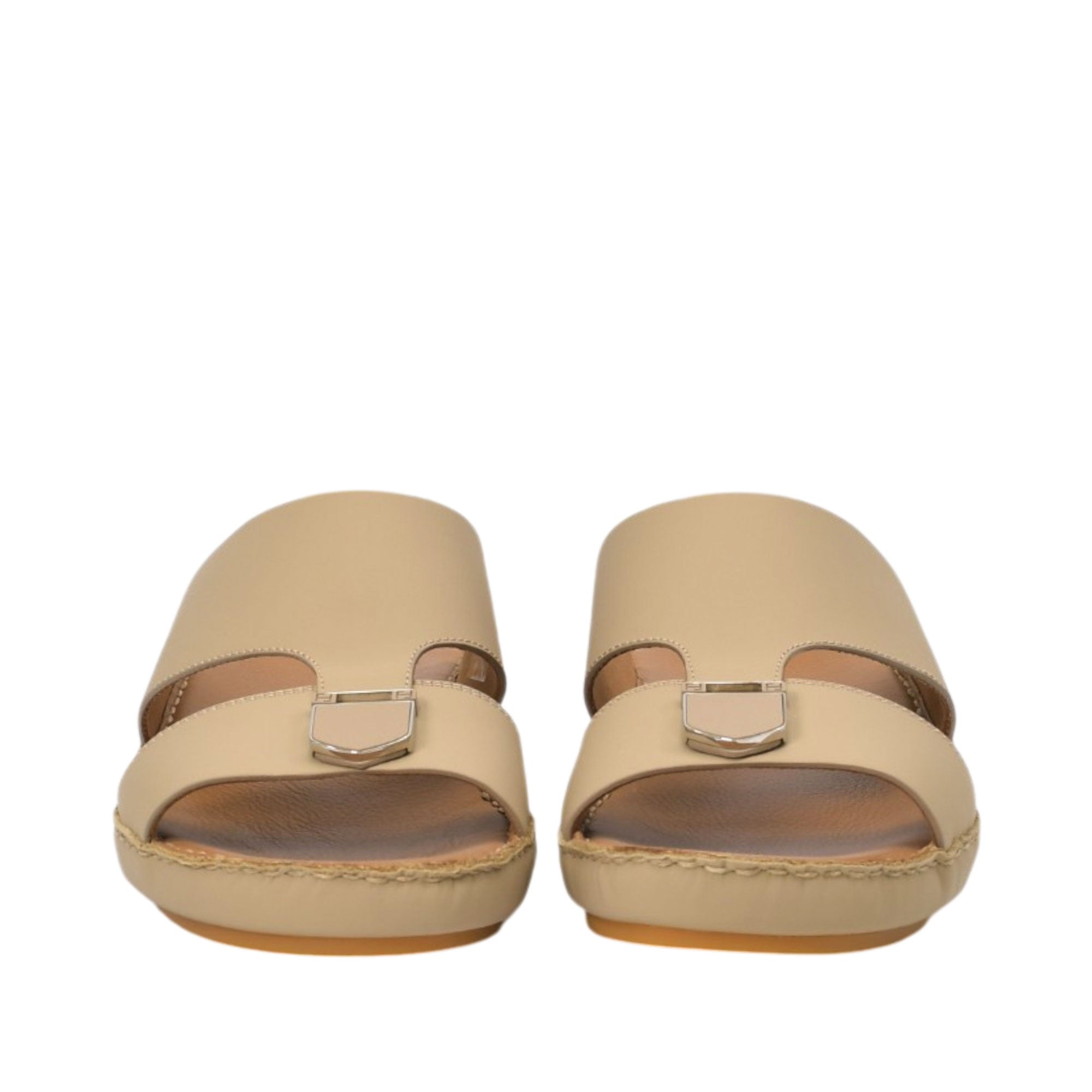 Front-facing view of a pair of FARES beige leather comfort sandals showcasing the wide toe-box opening and matching shield-shaped matte metallic buckle details on the front straps against a white background.