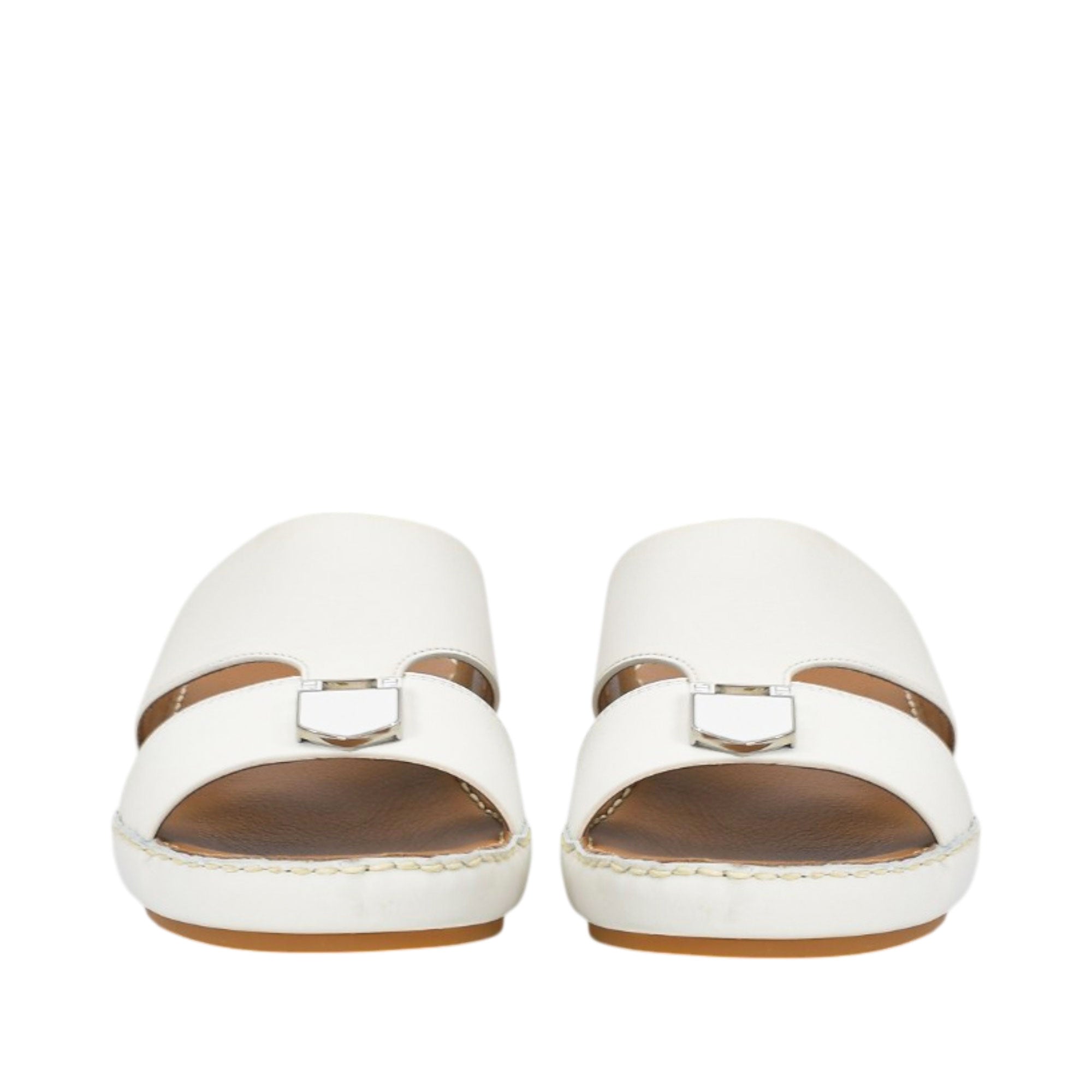 Front-facing view of a pair of FARES white leather comfort sandals showcasing the wide toe-box opening and matching shield-shaped matte metallic buckle details on the front straps against a white background.