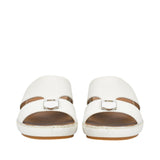 Front-facing view of a pair of FARES white leather comfort sandals showcasing the wide toe-box opening and matching shield-shaped matte metallic buckle details on the front straps against a white background.