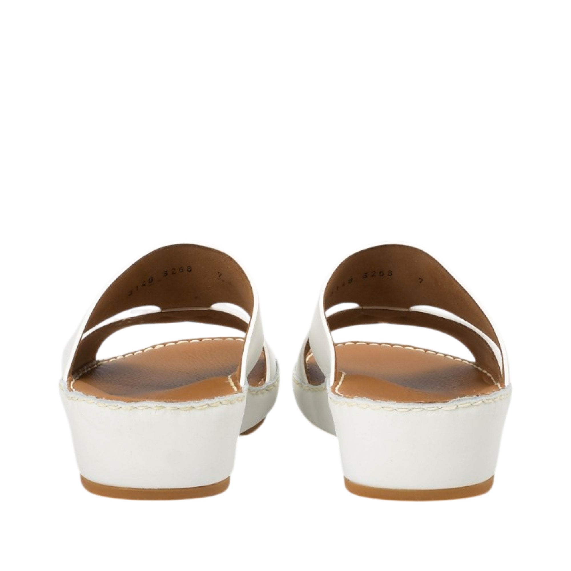 Rear view of a pair of FARES white leather sandals highlighting the sturdy, clean wedge heel construction and the interior sizing stamps printed on the smooth leather lining against a white background.