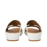 Rear view of a pair of FARES white leather sandals highlighting the sturdy, clean wedge heel construction and the interior sizing stamps printed on the smooth leather lining against a white background.