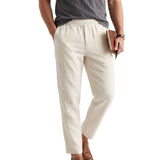 Off-white men's relaxed fit linen blend trousers with an elasticated waistband, side pockets, and a front fly closure.
