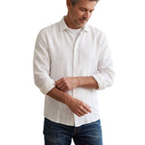 White linen long-sleeve button-up shirt with a standard collar, white buttons, and rolled-up sleeves.