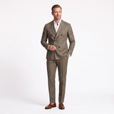 Ecru double-breasted suit with check pattern. Jacket has peak lapels, six dark buttons, and rounded patch pockets. Flat-front