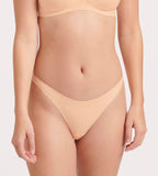 Front view of model wearing the Sloggi Body Adapt Twist Brazil panty in powder orange, highlighting the mesh waistband and seamless finish. Shop Online
