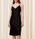 Front view of model wearing the Triumph Silky Sensuality black nightdress, highlighting the lace-trimmed neckline and fluid, shimmering fabric. Available for Online Purchase