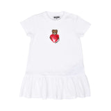 Front view of the Moschino kids baby girl white dress teddy heart print ruffle hem. Now Available Online