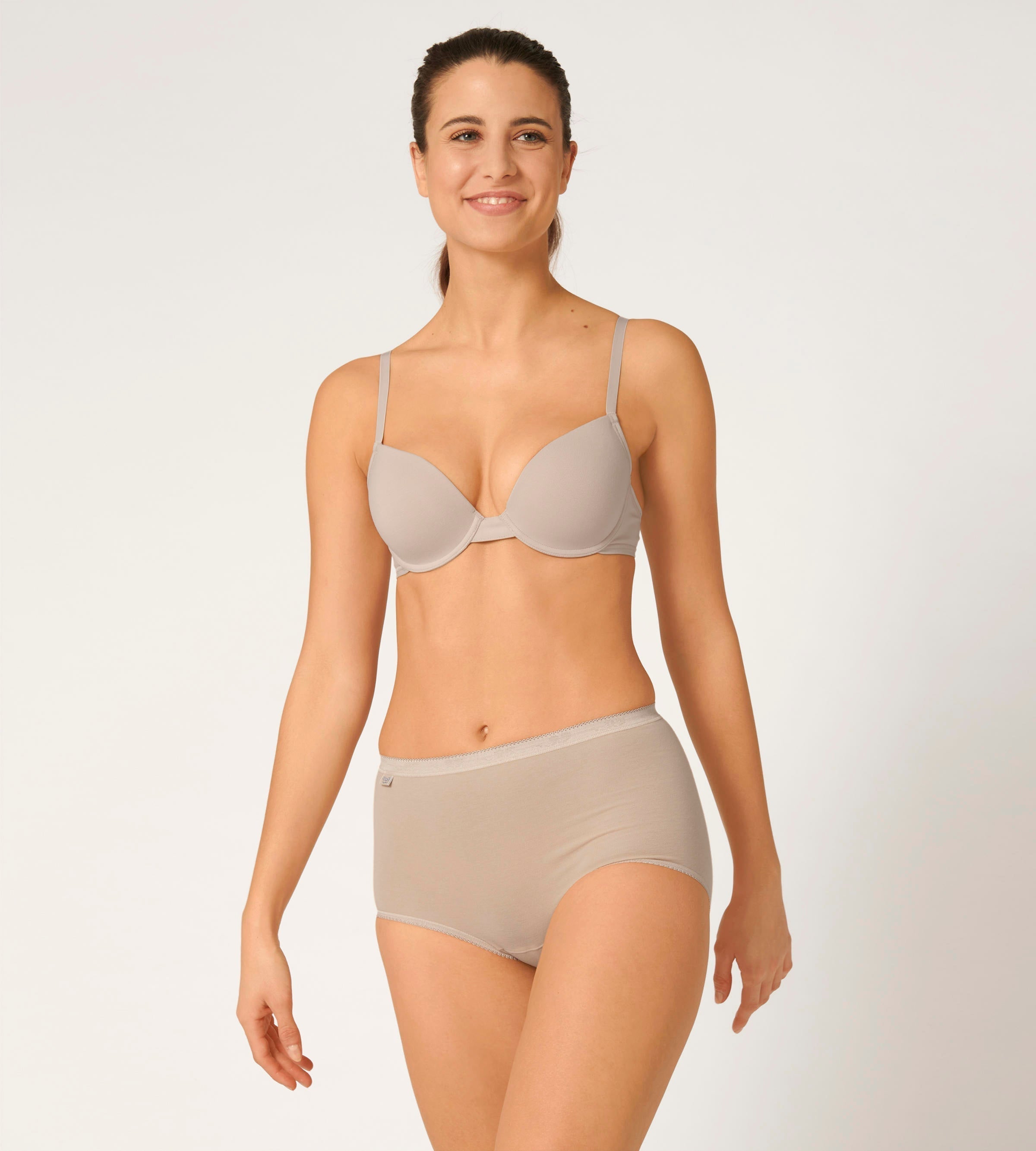 Full Front view of model wearing the Sloggi Basic+ beige maxi panties, showcasing the high-waisted silhouette and soft cotton texture. Shop Now Online
