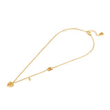 A full-length studio product presentation of the Escada Mina necklace, showing the gold-plated cable chain, the layered heart pendant with its side crystal charm, the inline monogram link, and the clasp assembly.