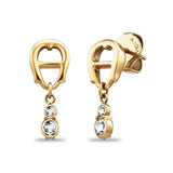 A high-resolution studio display of the Aigner Iva women's yellow gold-plated stainless steel earrings, showing one piece from the front highlighting the horseshoe stud and double-crystal drop, and the other tilted to display the post and branded Aigner butterfly backing.