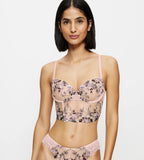 Full front view of model wearing the Triumph Sensual Spotlight light pink corset, showcasing the intricate lace panels and structured waist design. Now Available Online
