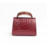 Rear view of the GAIA Victorian Mini bag highlighting the structured silhouette and the braided gold and teal leather top handle.