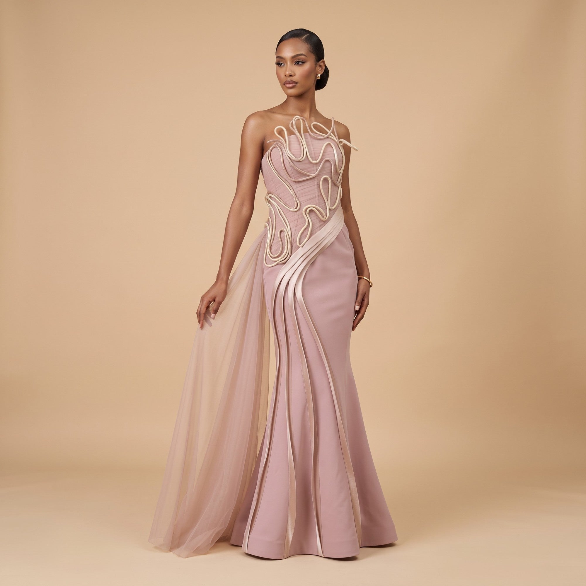 Pink one-shoulder mermaid gown with abstract cream cord embellishments and a sheer pink tulle side train.