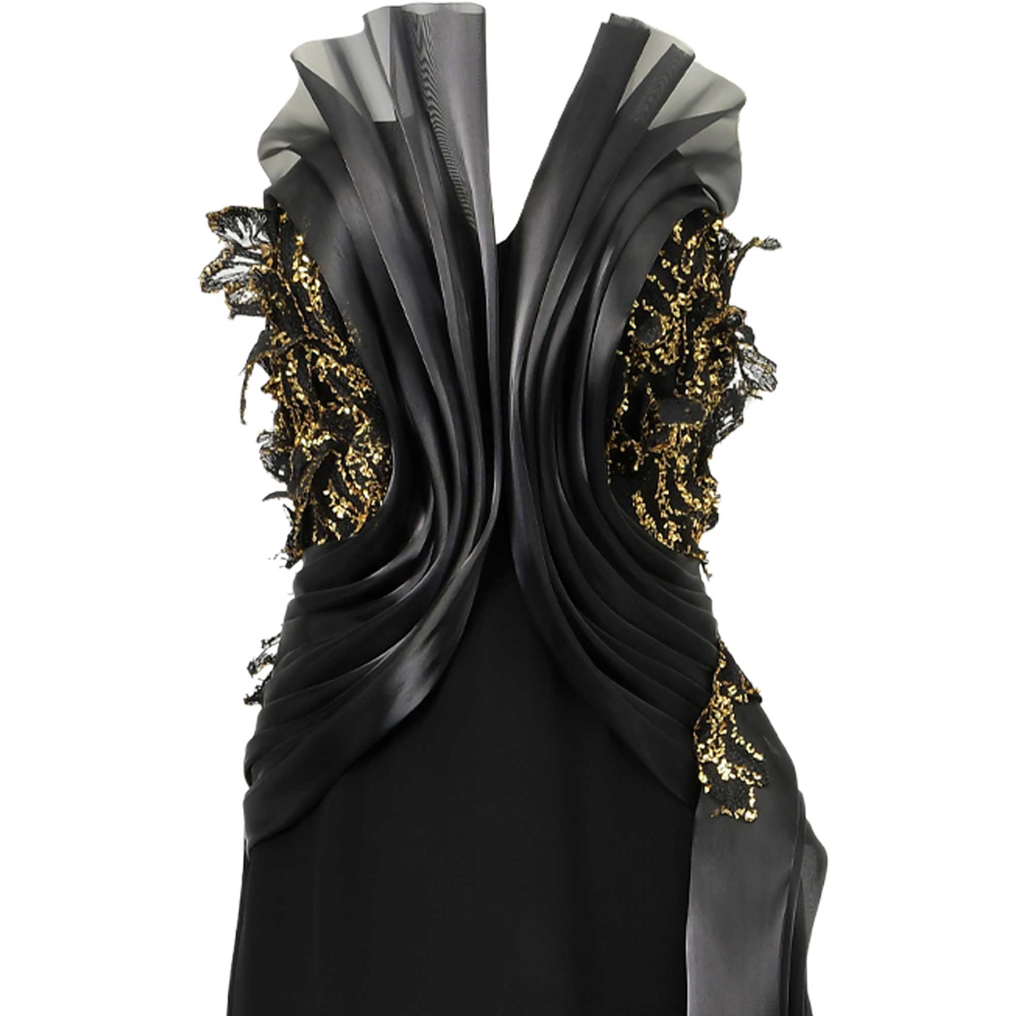 Black dress with a deep V-neck, sheer ruffled shoulders, and draped pleated bodice. Gold-toned sequined lace details adorn th