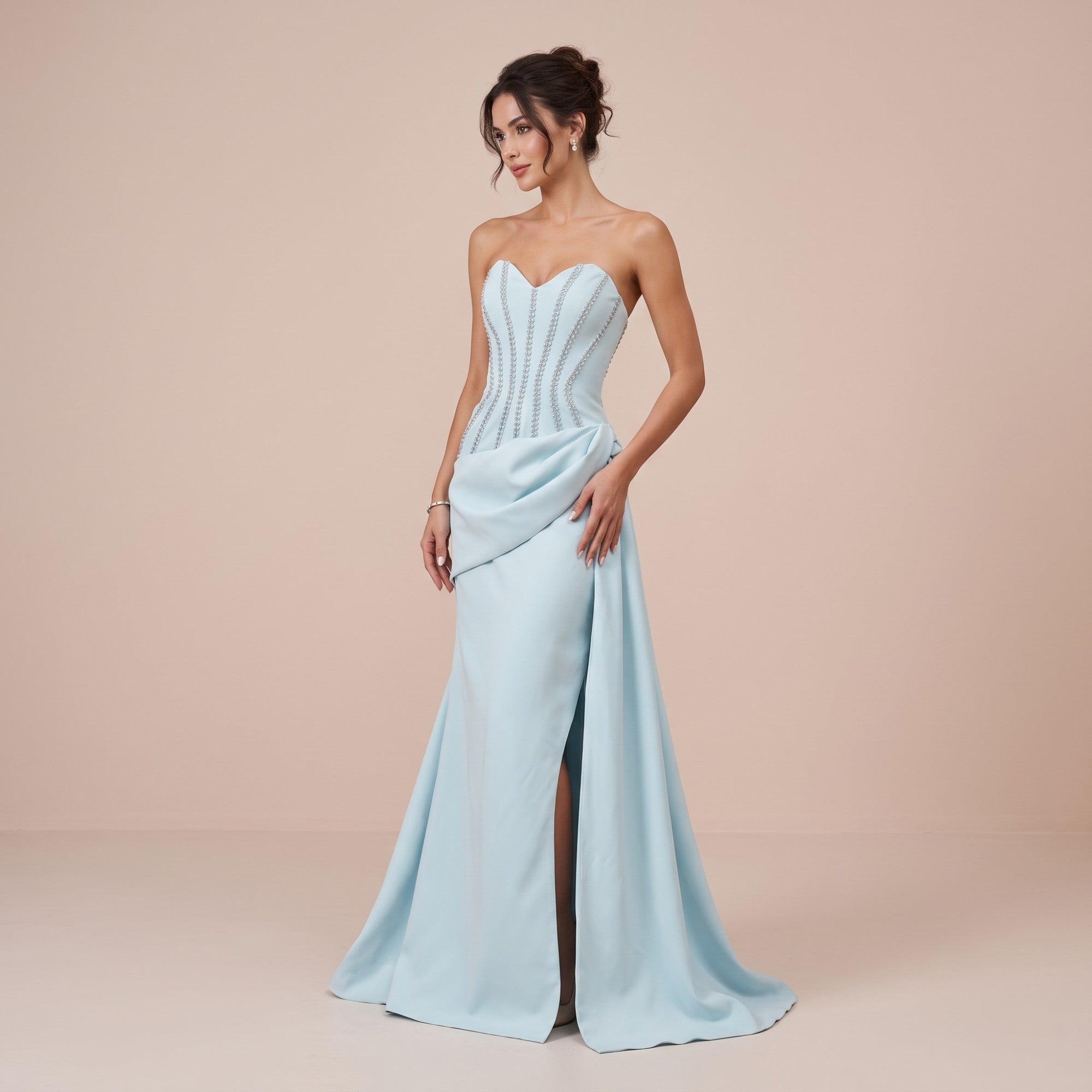 Light blue strapless floor-length gown with a sweetheart neckline, embellished bodice, and high leg slit.