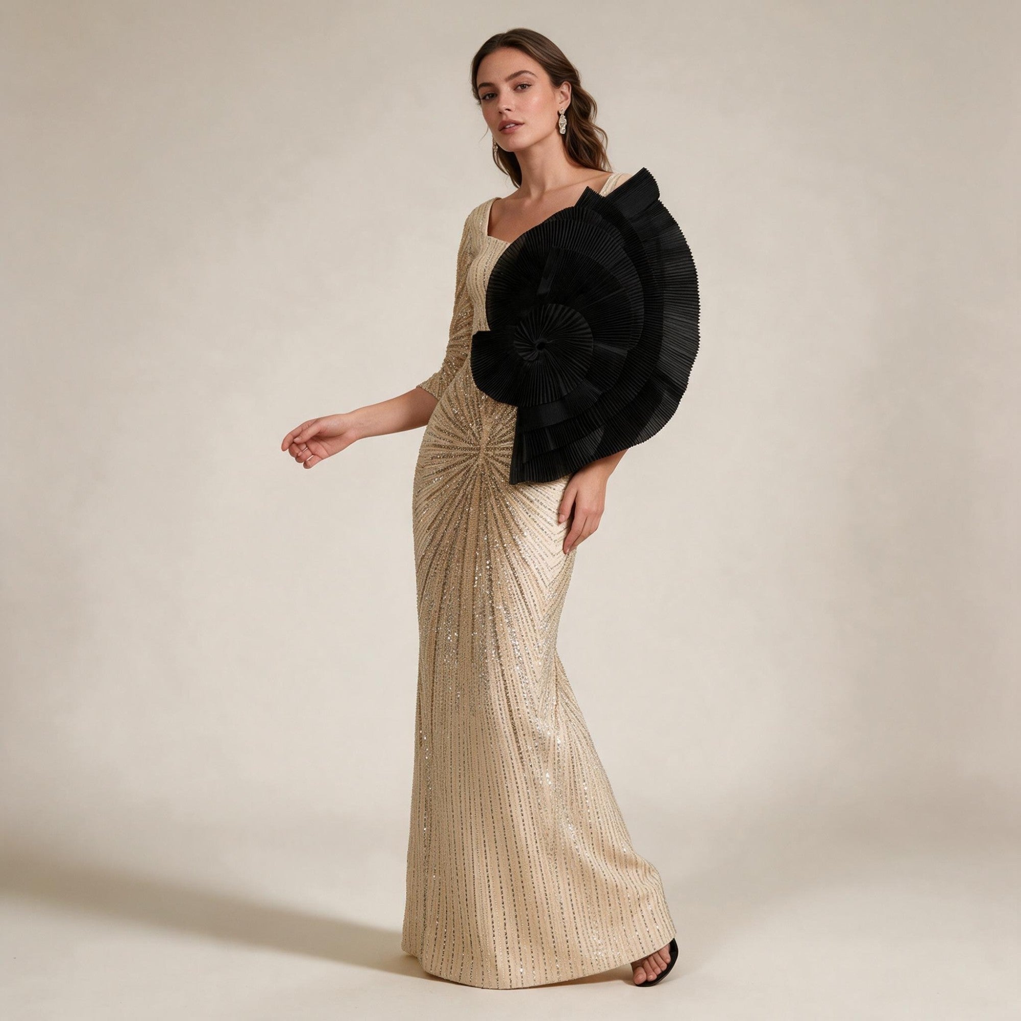 Gold-toned embellished floor-length gown with a square neckline, three-quarter sleeves, and a large black pleated shoulder de