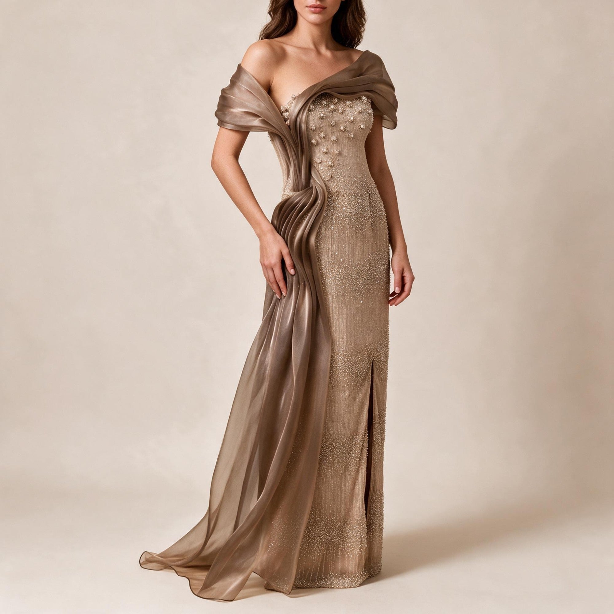 Bronze off-shoulder floor-length gown with intricate beadwork, floral appliqués, a sheer draped panel, and a high side slit.