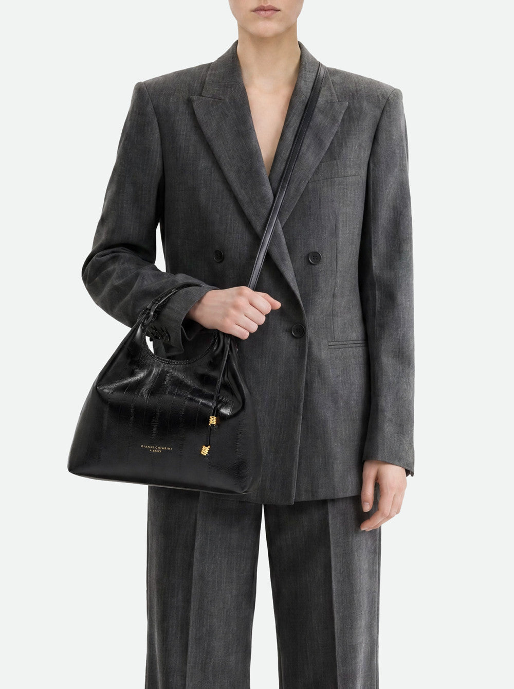 Black crocodile-embossed leather handbag with a drawstring top, gold-toned toggles, a top handle, and a shoulder strap. Gold