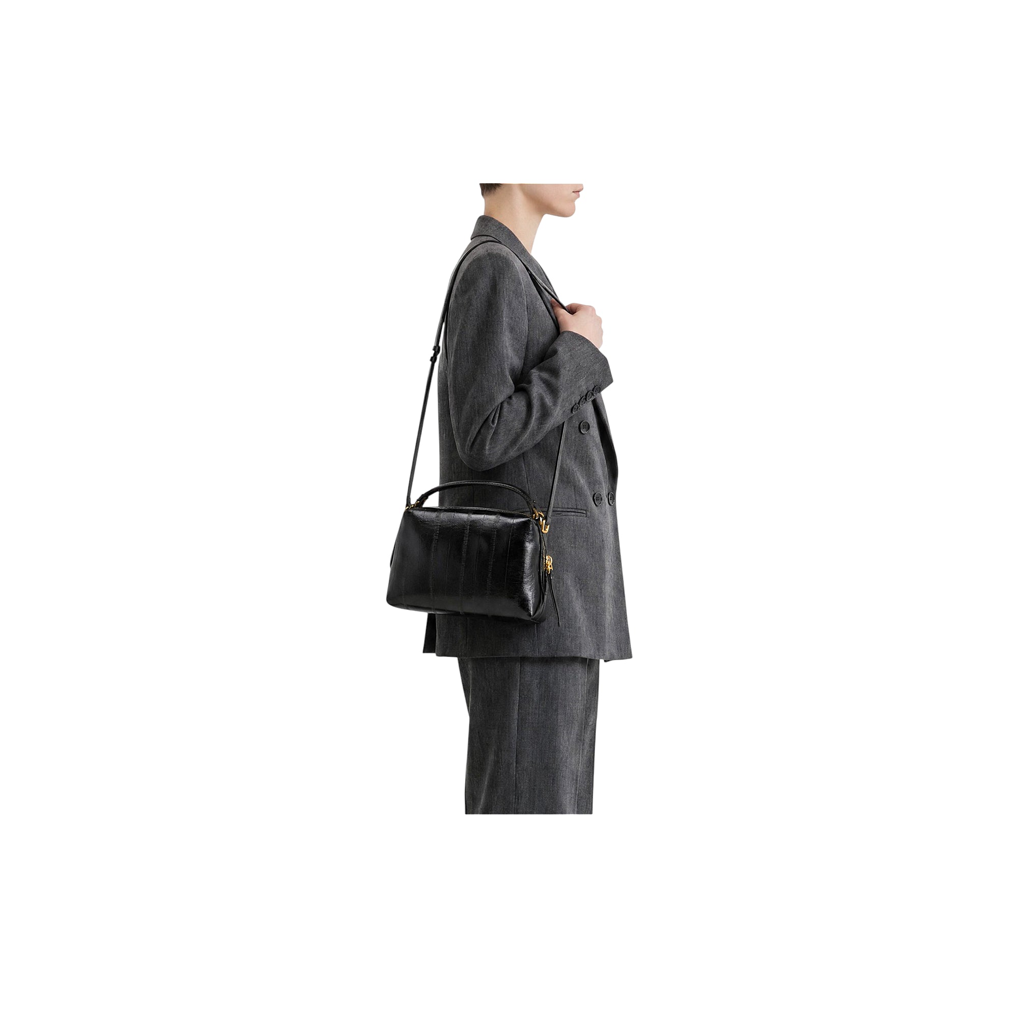 Black textured leather handbag with a top handle, thin shoulder strap, gold-toned zipper, and vertical textured panels.