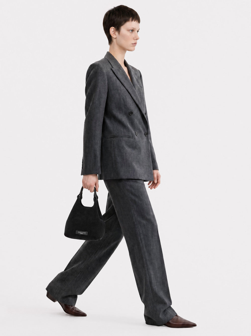 Black soft fabric crescent handbag with a single top handle and a small black brand label on the front.