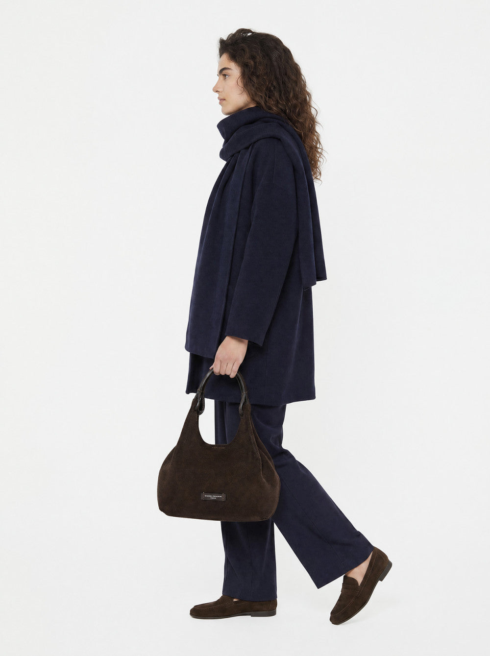 Dark brown hobo handbag with a soft, suede-like finish, a dark brown textured top handle, and a small brand label on the fron