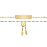 Gold-toned bracelet with a central bar engraved with a Greek key pattern. Features a round bolo clasp with a logo and two dan