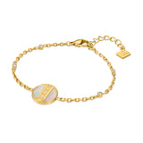 Gold-toned chain bracelet with a circular white mother of pearl inlay featuring a gold Greek key pattern and clear stone acce