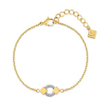 Gold-toned chain bracelet with a central silver-toned wire-wrapped ring and square gold-toned links with etched designs.