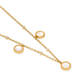 Gold-toned necklace with delicate chain, featuring three round mother-of-pearl pendants with patterned borders and clear crys