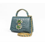 Side angle of the GAIA Victorian Mini bag showing the detachable gold chain crossbody strap and textured crocodile finish.