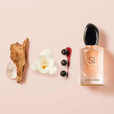 Giorgio Armani Si perfume bottle with natural elements on a pink background