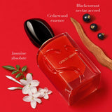 Red Giorgio Armani perfume bottle with floral and fruit elements on a red background.