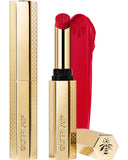 Guerlain KissKiss Honey-Infused Matte Lipstick in its signature slim golden honeycomb case, alongside an open cherry-red lipstick bullet and creamy velvety texture smudge, available at blue salon.