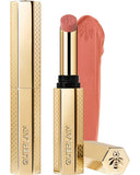 Guerlain KissKiss Honey-Infused Matte Lipstick in its signature slim golden honeycomb case, shown with an open deep burgundy-brown lipstick bullet and a velvety color smudge texture, available at blue salon.