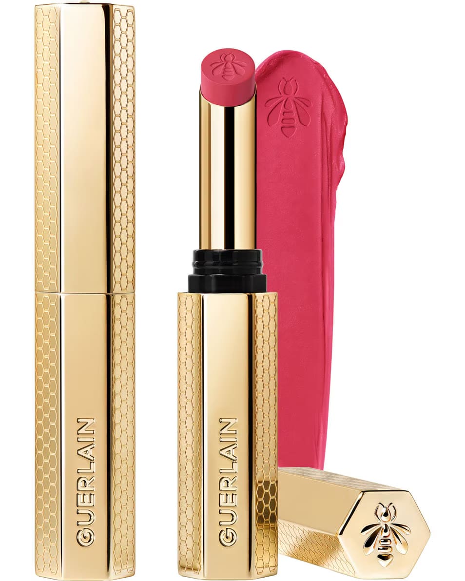 Guerlain KissKiss Honey-Infused Matte Lipstick in its signature slim golden honeycomb case, featured alongside an open bright rose-pink lipstick bullet and creamy velvety color swatch, available at blue salon.