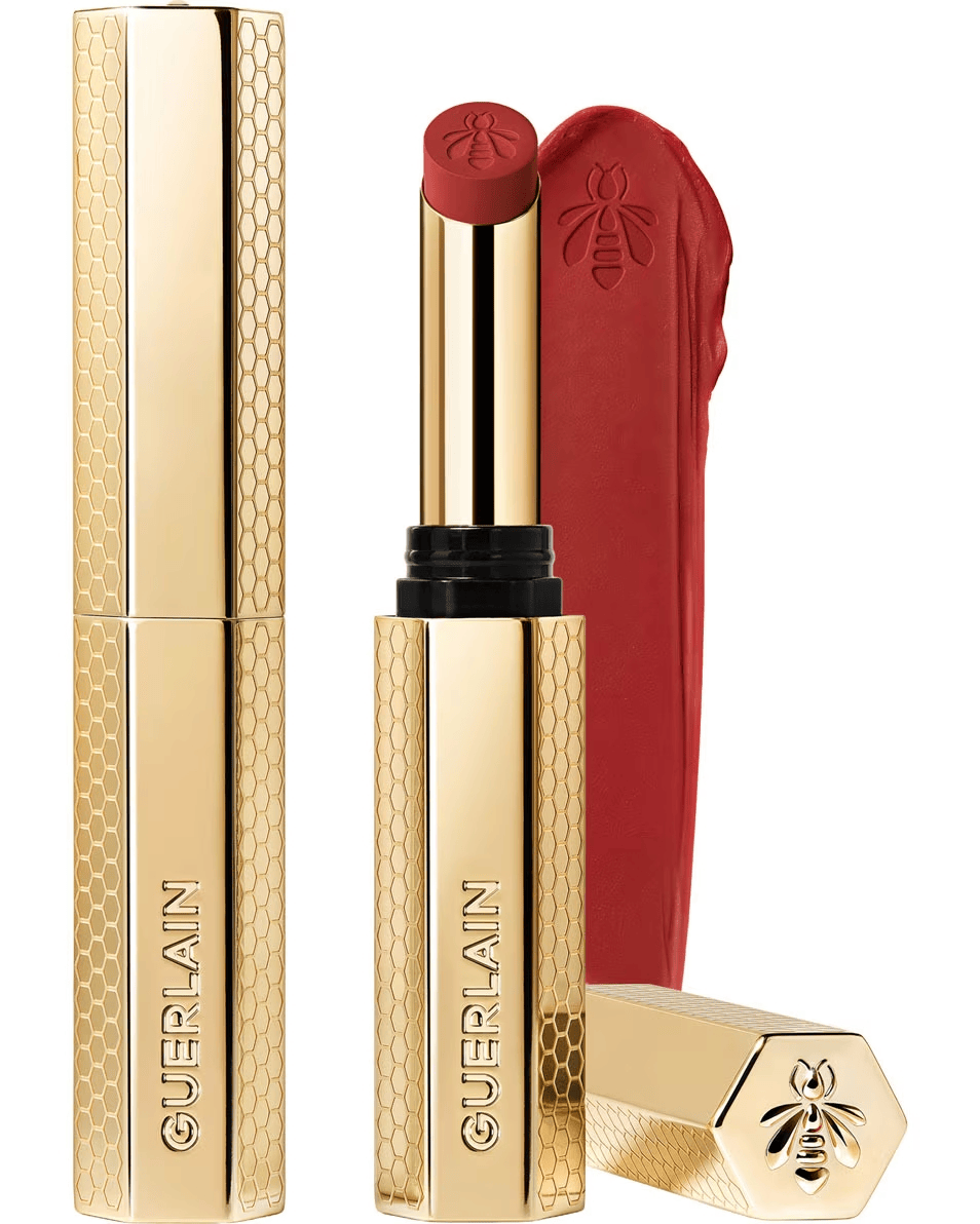 Guerlain KissKiss Honey-Infused Intense Lipstick in its slim, refillable golden honeycomb case, shown next to a rich red lipstick bullet and texture smudge, available at blue salon.