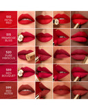 A shade reference guide displaying five velvety matte red lip swatches across diverse skin tones, featuring Guerlain shades Petal Red, Primrose Bliss, Pure Hibiscus, Red Bouquet, and Red Aster from blue salon.