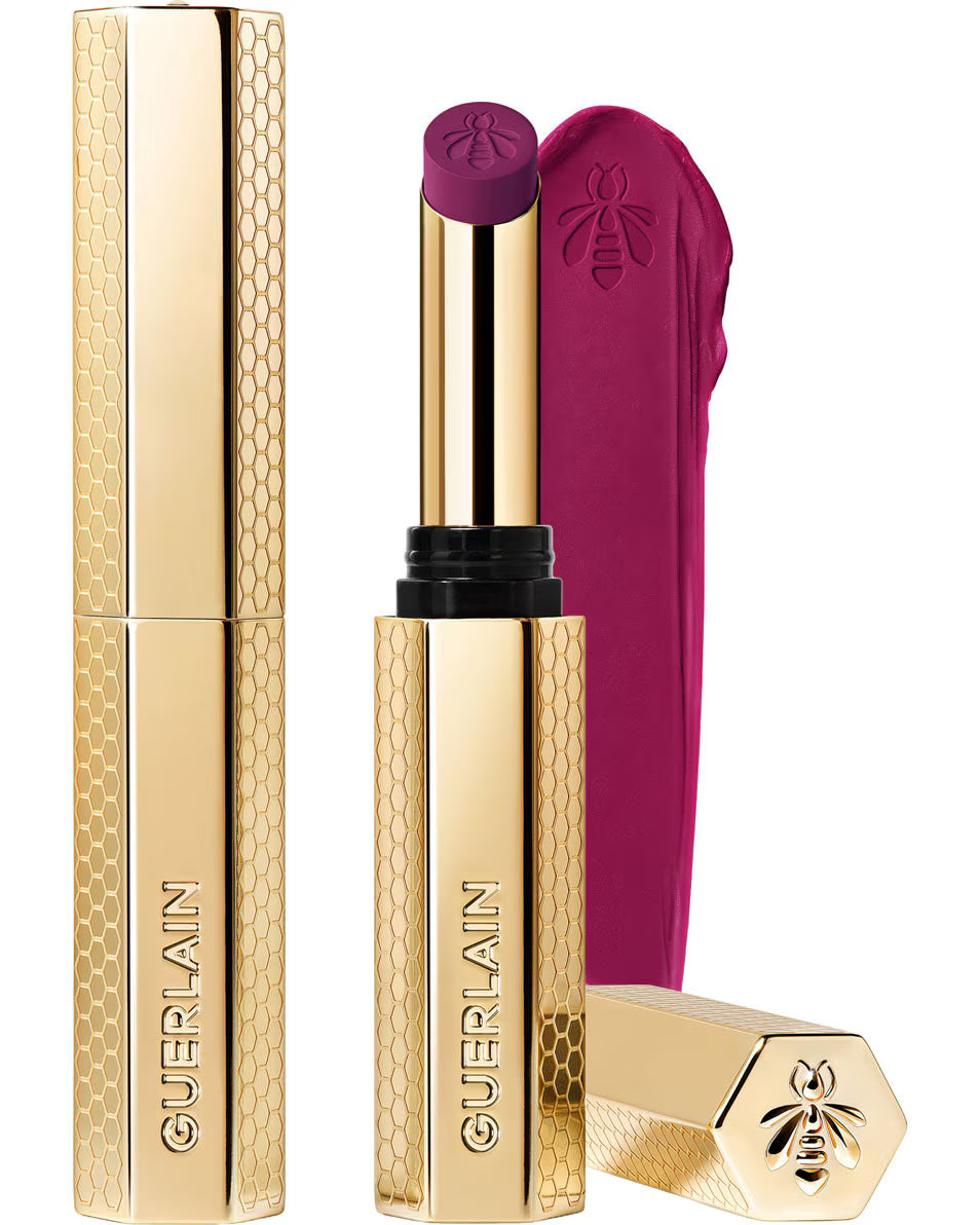Guerlain KissKiss Honey-Infused Matte Lipstick in its signature slim golden honeycomb tube, featuring an open deep plum-berry lipstick bullet next to a velvety color smudge, available at blue salon.