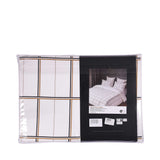 White duvet cover and pillow case set with a grid pattern of thin black and gold-toned vertical and horizontal stripes.