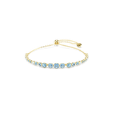A high-resolution direct frontal studio shot of the Swarovski Imber bracelet laid out on a white surface, displaying its graduating strand of vibrant blue round crystals and its adjustable gold-finished chain.