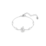A high-resolution direct frontal studio shot of the Swarovski Swan bracelet laid out on a white surface, displaying the crystal-pave swan emblem, marquise crystal station links, and the adjustable extension chain.