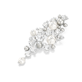 A high-angle studio laydown view of the Swarovski Constella brooch, showcasing how the brilliant round-cut clear crystals catch the light and contrast against the satin luster of the white and silver pearls.