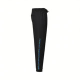 Black joggers with elastic waist, drawstring, side pockets, and elastic cuffs. Left leg has a blue/green patterned side strip