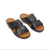Black leather slip-on sandals with tan footbeds. Two wide straps, front strap has a silver-toned rectangular buckle. Black st