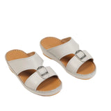 Pair of white open-toe kids' slippers with two straps and a silver-toned rectangular buckle on the wider strap.