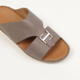 Taupe leather slip-on sandal with tan insole, featuring a wide upper strap with side cut-outs and a silver-toned rectangular
