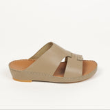 Taupe leather slip-on sandal with a wide upper strap, cut-out design, and a small vertical loop detail. Brown insole, light b